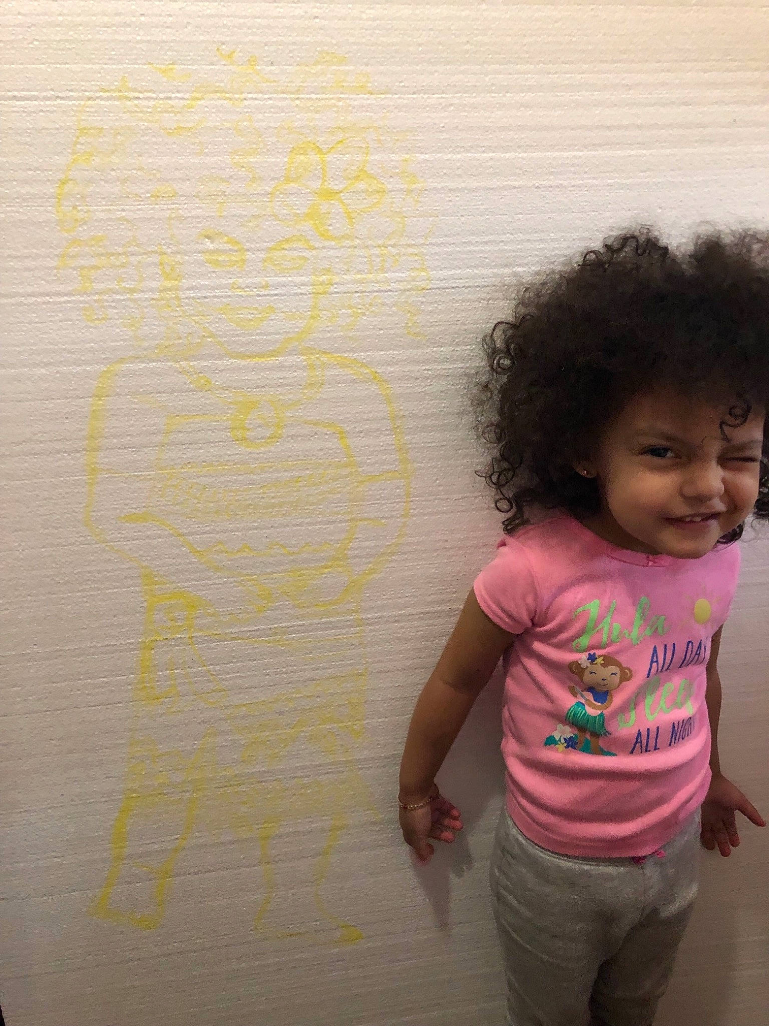 Gianna is registered to the contest to win money with this photo: cheek, child, face, fun, hair, happy, head, joy, nose, person, pink, play, skin, smile, standing, toddler, wall