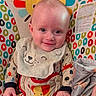 baby, infant, smiling, child, bib, onesie, blanket, colorful, baby_seat, patterned, animal_print, face, happy, cute, indoor, portrait, clothing, comfort, toddler, young_child