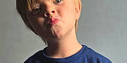Eli joined the competition — help win amazing prizes! blond_hair, blue_tshirt, boy, casual_clothing, child, cute, expression, fashion, head_and_shoulders, human, indoor, person, plain_background, playful, portrait, pouting, short_sleeves, smile, studio_lighting, young