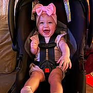 Lucelia is registered to the contest to win money with this photo: baby, infant, child, car_seat, headband, bow, smile, laughing, happy, harness, seat, socks, legs, portrait, indoor, pink, adorable, cozy, face, accessory
