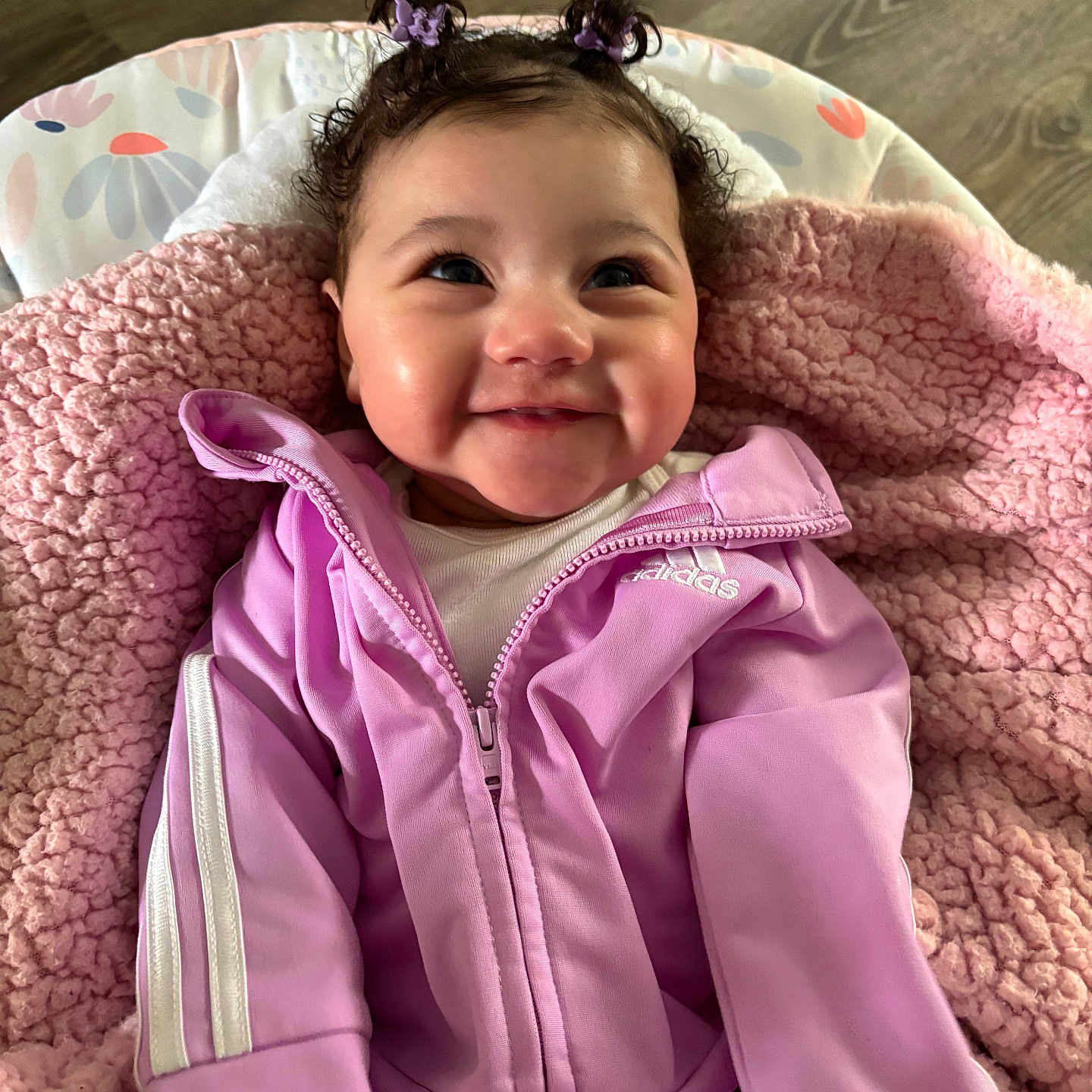 Alani joined the competition — help win amazing prizes! adidas, apparel, baby, child, clothing, cute, face, flooring, hair_buns, happy, hoodie, indoor, jacket, person, pink_blanket, portrait, purple_jacket, sitting, smiling, young_child