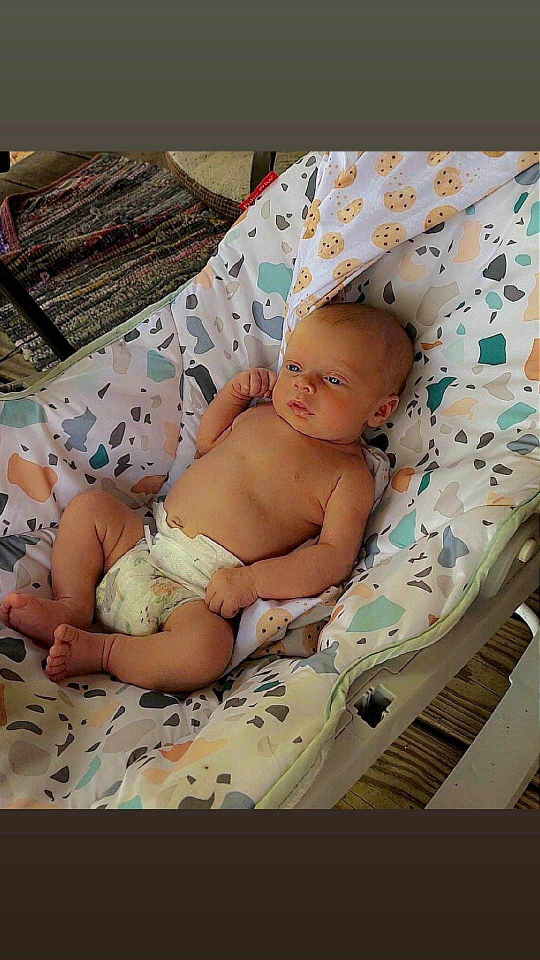 August joined the competition — help win amazing prizes! baby, infant, diaper, baby_rocker, patterned_fabric, indoor, wooden_floor, blanket, relaxed, cute, child, person, seated, comfort, soft_toys, home, resting, baby_girl, baby_boy, newborn
