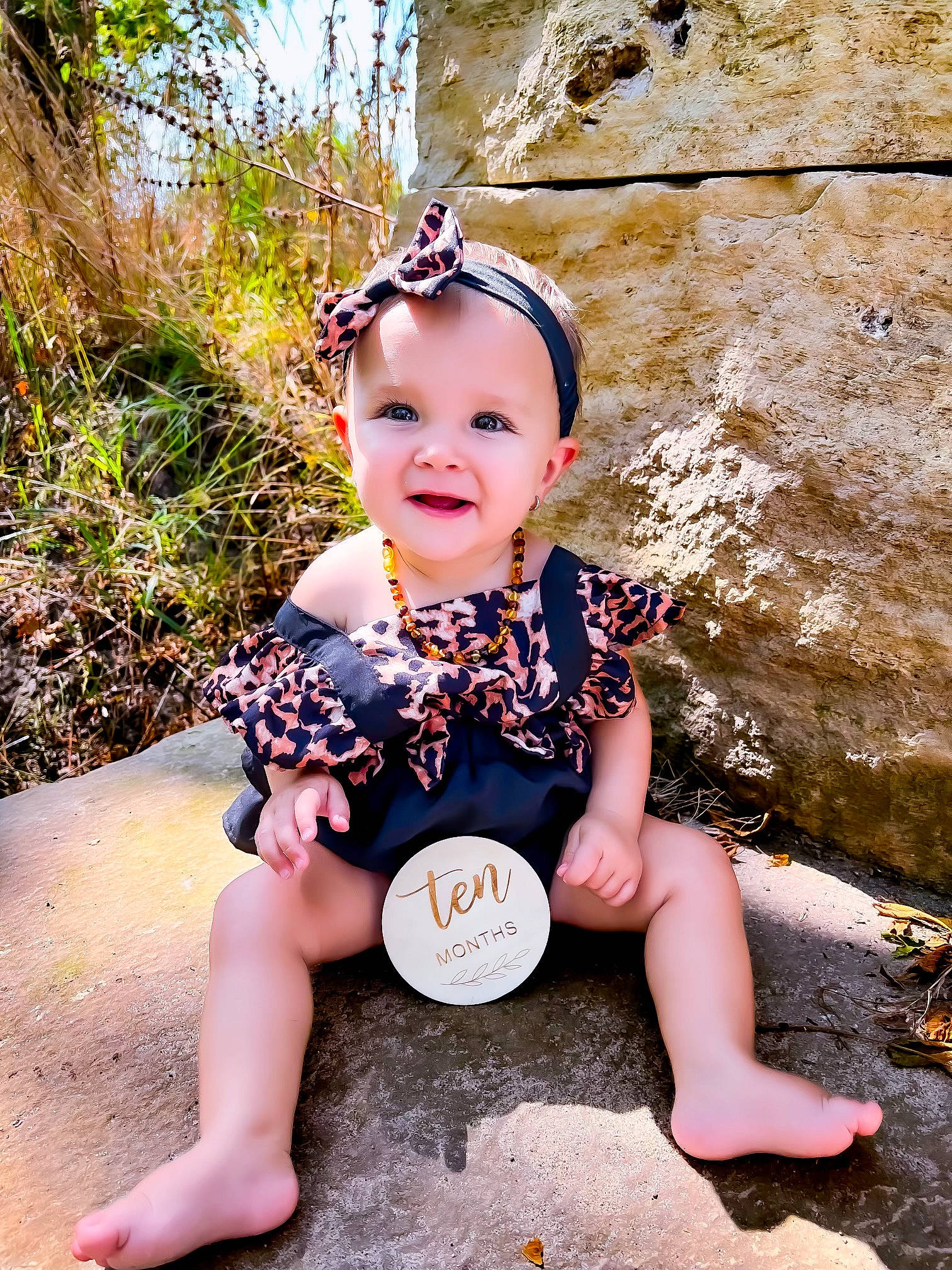 Amia is registered to the contest to win money with this photo: baby, baby_toddler_clothing, child, eye, fawn, fun, grass, happy, headpiece, human_leg, joy, leaf, leisure, people_in_nature, person, plant, sitting, smile, t_shirt, thigh