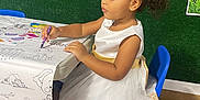 Eliana is registered to the contest to win money with this photo: accessories, bodypart, chair, child, clothing, crown, dress, face, female, finger, furniture, girl, head, jewelry, pen, person, photography, portrait, sitting, wood