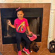 Eliana joined the competition — help win amazing prizes! child, girl, peace_sign, pink_shoes, pink_purse, fireplace, tile_floor, dog, indoor, smile, casual_clothing, decor, home, pet, happy, person, standing, black_dog, bright_colors, playful