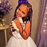Eliana joined the competition — help win amazing prizes! child, girl, puppy, dog, braided_hair, purple_bow, white_dress, smiling, hugging, indoor, portrait, cute, happy, pet, flowers, table, decor, lights, beads, toddler