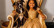 Eliana is registered to the contest to win money with this photo: basket, child, costume, crown, curly_hair, decor, dog, dress, floor, furniture, golden, happy, indoor, luxury, pet, portrait, princess, royalty, smile, throne