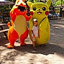 bench, boy, charmander, child, costume, daytime, footwear, fun, hat, mascot, nature, outdoor, park, pikachu, playful, sand, shorts, smile, sunlight, trees