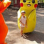 boy, character, child, costume, daylight, footwear, fun, hat, mascot, nature, outdoor, park, pikachu, playful, sand, shadow, shorts, smile, trees, white_shirt