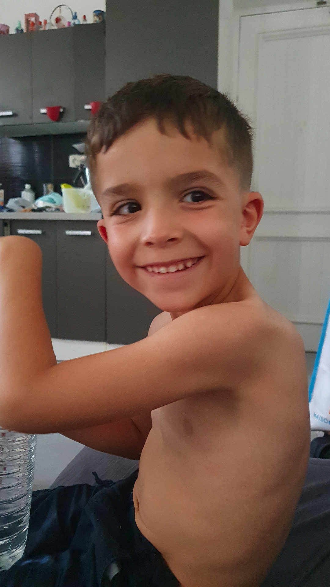Milan Andrea a rejoint le concours — aidez-le/la à gagner de superbes lots ! child, boy, smiling, shirtless, water_bottle, kitchen, cabinet, door, short_hair, happy, indoor, furniture, person, young, casual, home, light, skin, face, arm