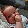 baby, infant, face, hand, thumb_sucking, clothing, pacifier, lying_down, close_up, cute, child, sleeping_area, blanket, cartoon_character, skin, expression, indoor, soft_toys, comfort, relaxation