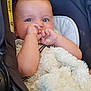 baby, infant, car_seat, blanket, blue_eyes, face, hand, thumb_sucking, comfort, cute, child, young, soft_texture, cozy, indoor, person, clothing, seat, closeup, portrait