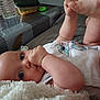 baby, infant, thumb_sucking, blanket, onesie, cartoon_character, donkey, curious_eyes, chubby_cheeks, indoor, table, water_bottle, container, soft_texture, cute, lying_down, close_up, person, child, comfort