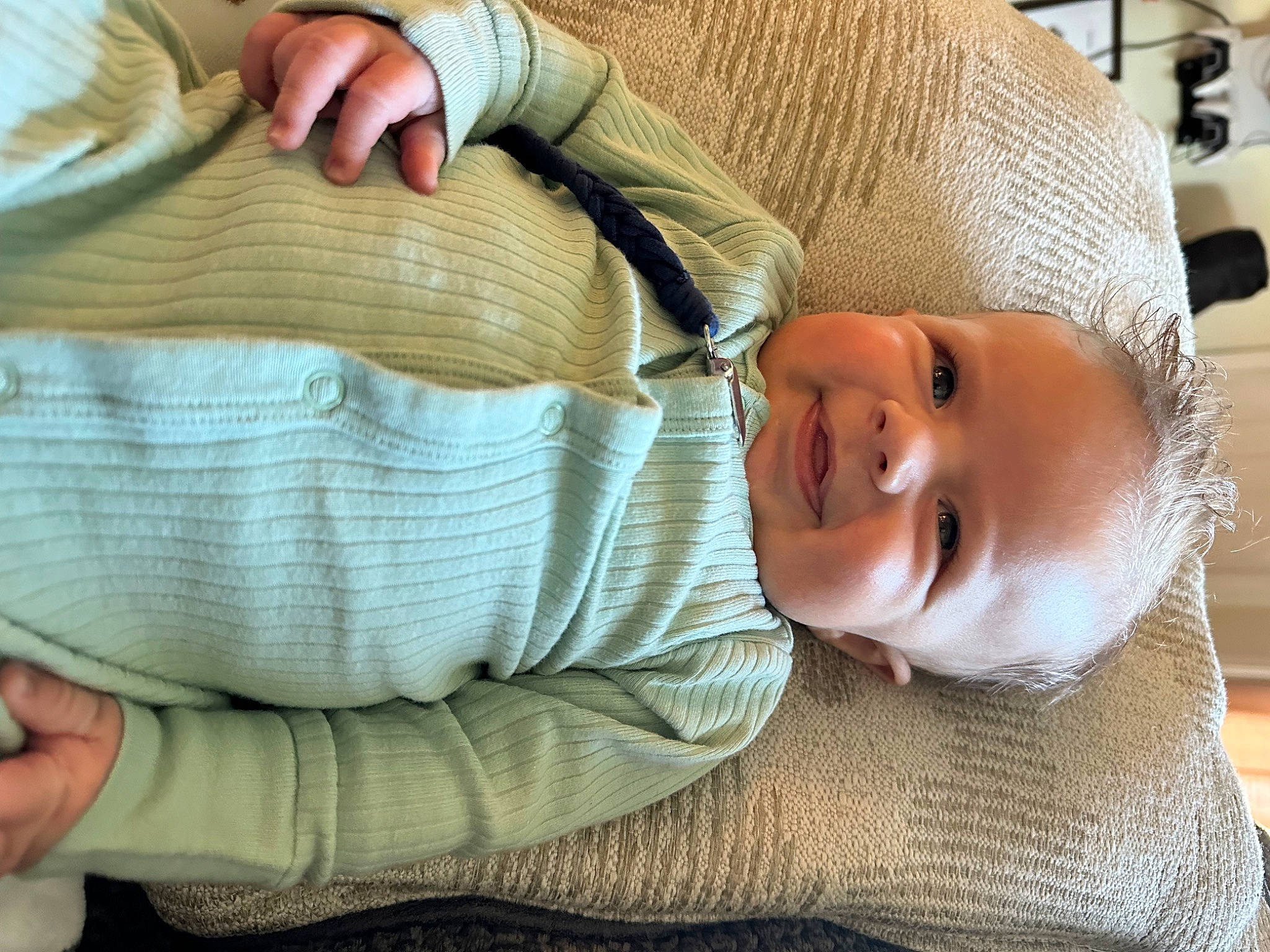Oliver is registered to the contest to win money with this photo: baby, baby_toddler_clothing, cheek, child, comfort, elbow, eye, finger, gesture, hand, head, human_body, linens, mouth, nose, person, skin, sleeve, smile, toddler