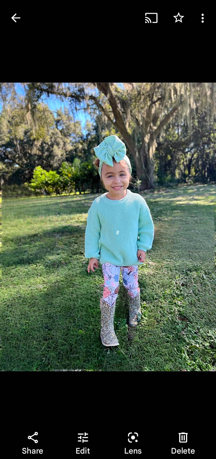 Liliana is registered to the contest to win money with this photo: baby_toddler_clothing, cap, cool, fun, grass, grassland, happy, hat, headwear, joy, leisure, magenta, pattern, people_in_nature, person, plant, sky, sleeve, smile, tints_and_shades