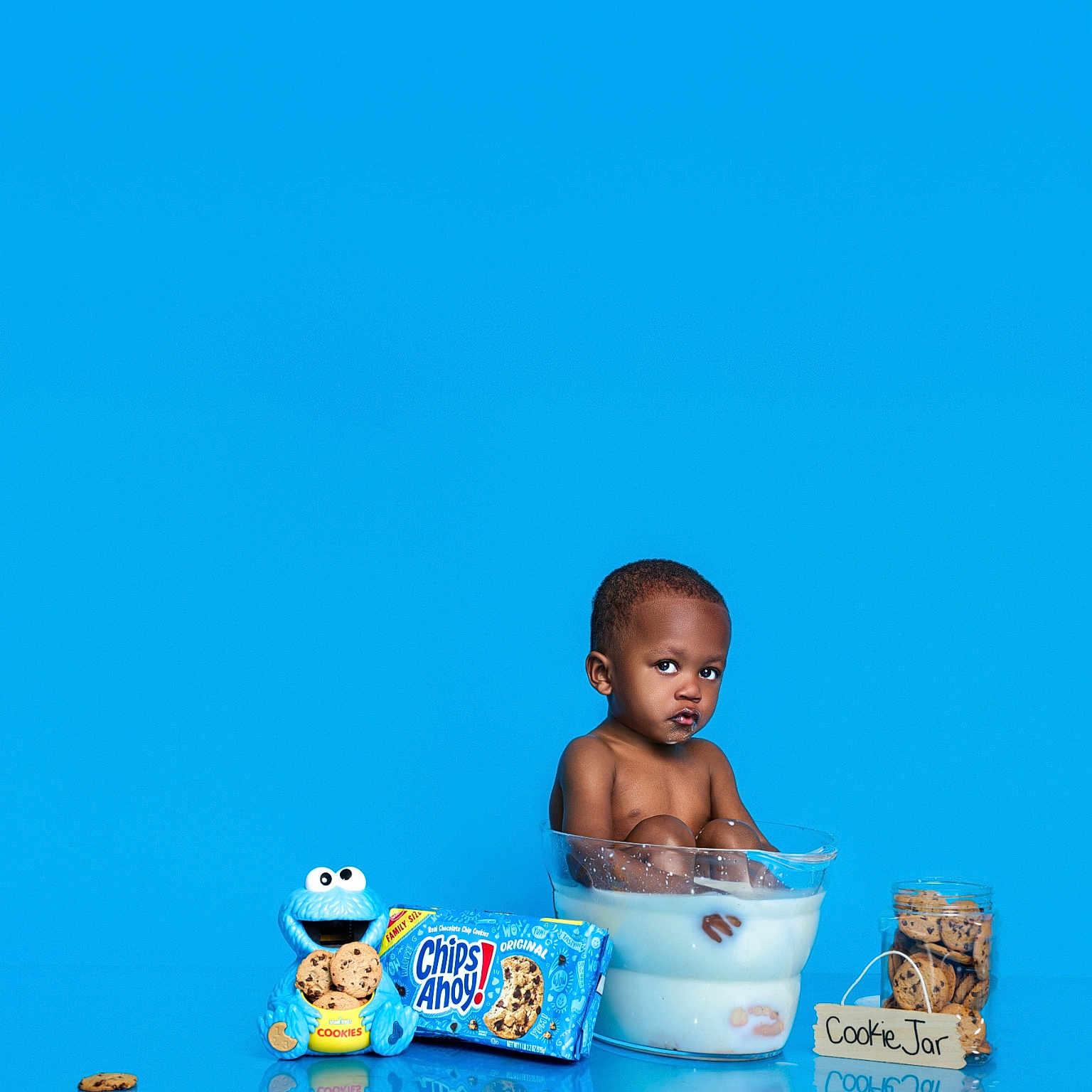 Chad is registered to the contest to win money with this photo: blue_background, child, chips_ahoy, cookie, cookie_jar, cookie_monster, cookies, cute, food, funny, glass_bowl, milk, milk_bath, playful, portrait, reflection, sitting, snack, studio_shot, toddler