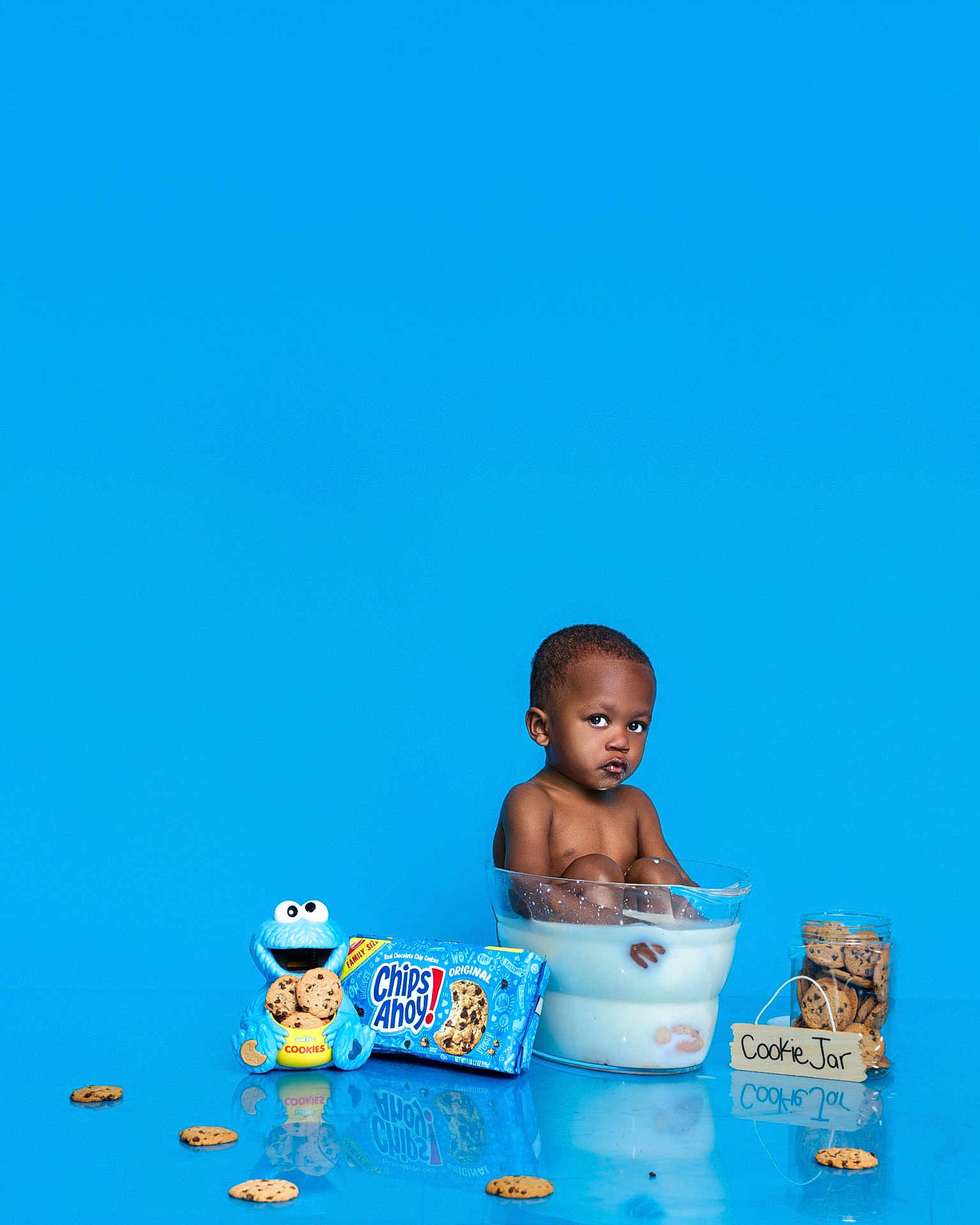 Chad is registered to the contest to win money with this photo: toddler, child, milk, cookie, cookies, cookie_jar, chips_ahoy, cookie_monster, blue_background, glass_bowl, milk_bath, snack, food, playful, cute, studio_shot, reflection, sitting, portrait, funny