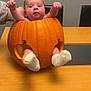 baby, pumpkin, table, sock, hand, orange, face, child, holiday, autumn, cute, indoor, celebration, person, furniture, chair, smile, skin, holiday_decoration, festive