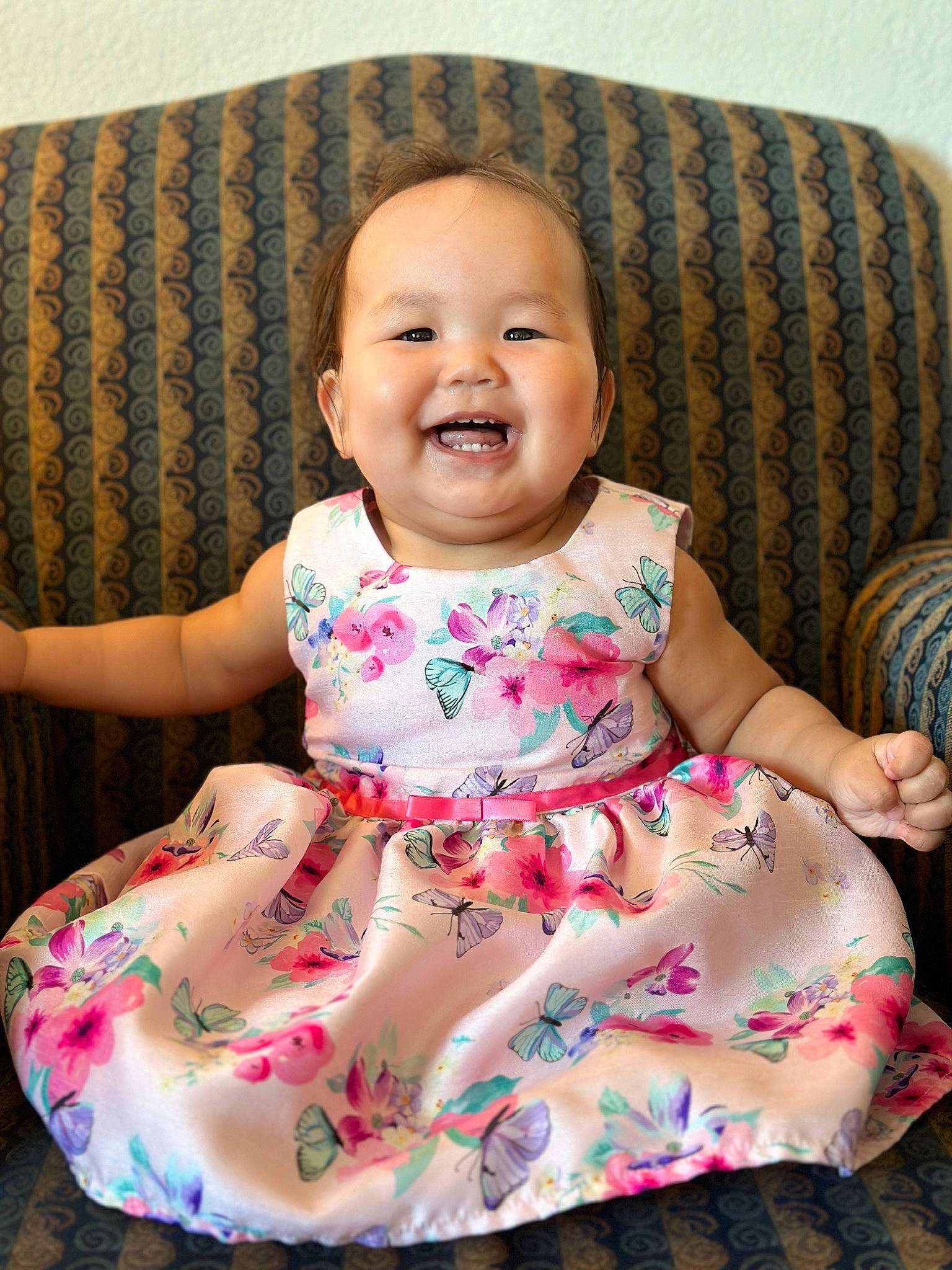 Allison is registered to the contest to win money with this photo: baby, baby_toddler_clothing, chair, cheek, child, comfort, day_dress, dress, happy, joy, one_piece_garment, pattern, people, person, pink, purple, sitting, skin, sleeve, smile