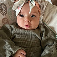 Elena is registered to the contest to win money with this photo: baby, headband, infant, clothing, cushion, pattern, face, hand, portrait, cute, child, expression, indoor, person, fabric, green, seat, closeup, young, soft