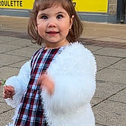 Sofia joined the competition — help win amazing prizes! child, girl, red_bow, white_jacket, plaid_dress, smiling, outdoor, sidewalk, flower, young_child, happy, portrait, casual_clothing, urban, cute, person, fashion, daylight, headwear, motion_blur