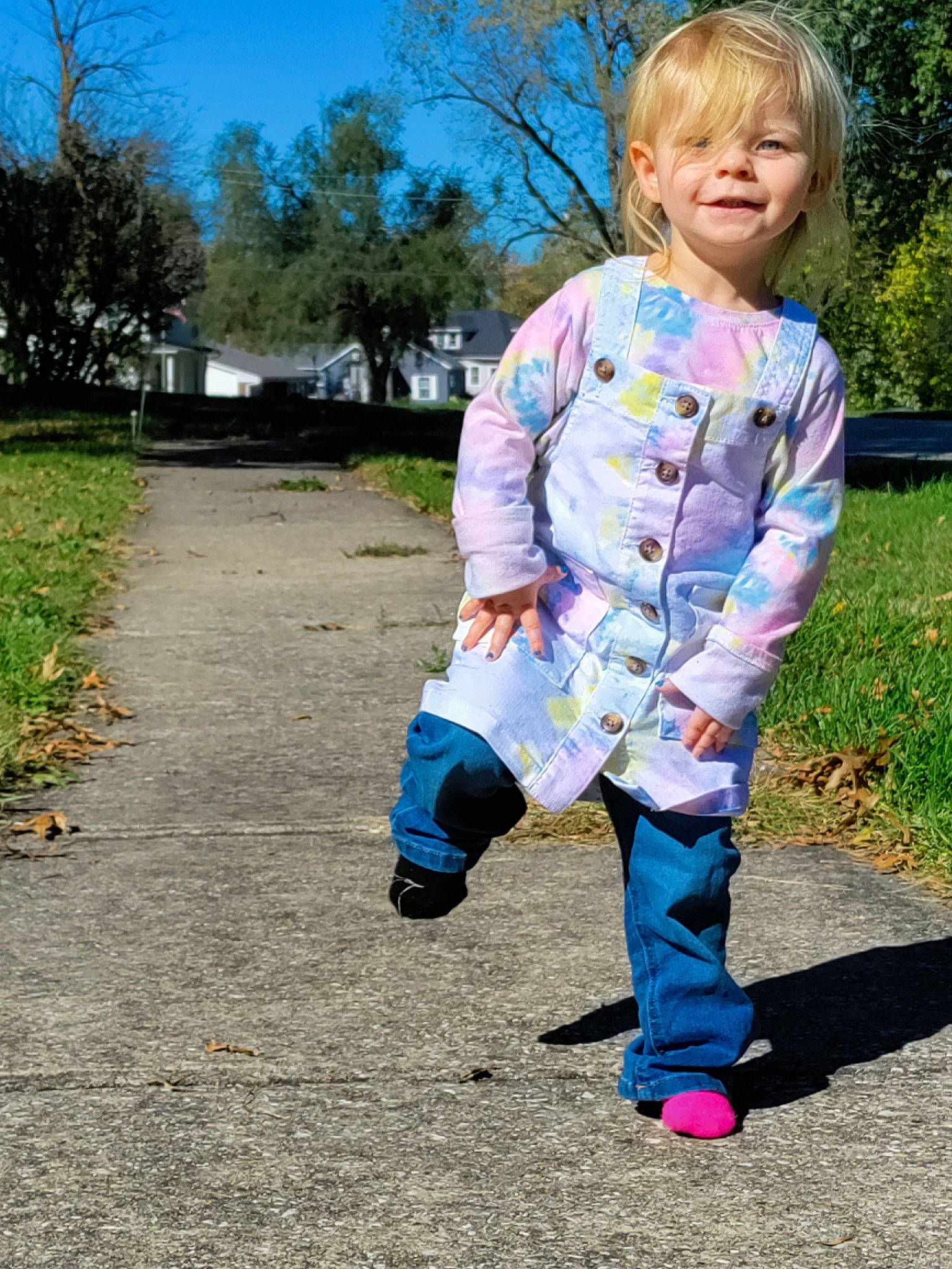 Myra is registered to the contest to win money with this photo: asphalt, baby_toddler_clothing, boot, denim, electric_blue, fun, grass, happy, joy, leisure, pattern, people_in_nature, person, plant, recreation, sitting, sky, sleeve, soil, toddler