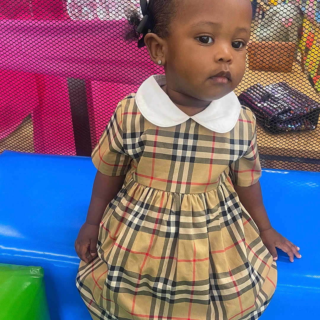 Tayler joined the competition — help win amazing prizes! ball, child, clothing, face, female, football, footwear, girl, happy, head, indoors, outdoorplayarea, outdoors, person, photography, playarea, portrait, shoe, sitting, sneaker