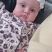 Harley joined the competition — help win amazing prizes! baby, headphones, couch, floral_outfit, headband, flower, indoors, child, cute, music, technology, relaxing, person, portrait, infant, expression, cozy, listening, hand, closeup