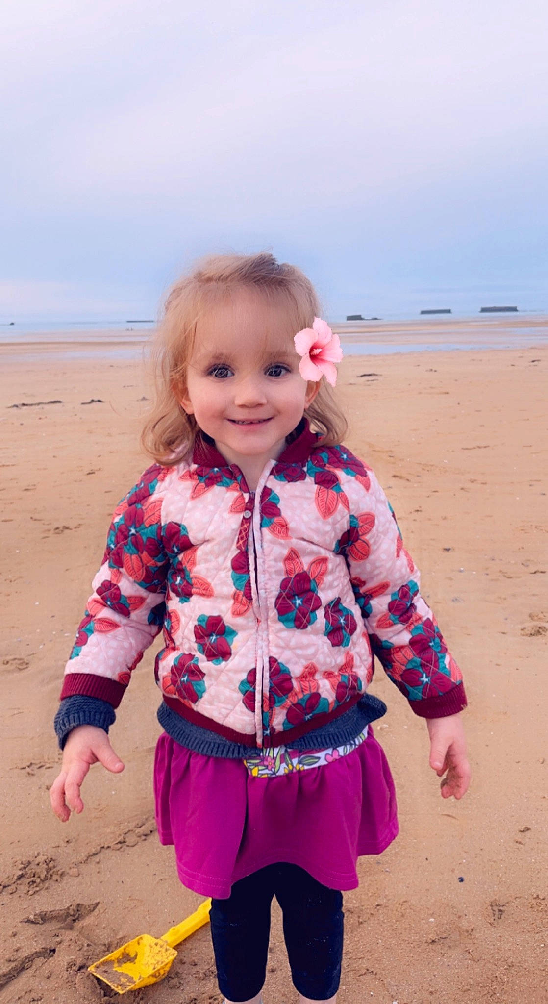 Chloé a rejoint le concours — aidez-le/la à gagner de superbes lots ! azure, baby_toddler_clothing, beach, body_of_water, eye, face, fun, happy, head, joy, people_in_nature, person, pink, sand, skin, sky, sleeve, smile, standing, toddler
