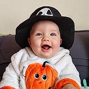 Célestin participe au concours pour gagner de l'argent avec cette photo : baby, black_hat, blue_eyes, child, clothing, cute, ghost_face, hands, happy, hat, hoodie, indoor, infant, keyboard, orange, person, playing, pumpkin, smiling, toy