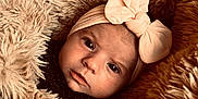 Victoire a rejoint le concours — aidez-le/la à gagner de superbes lots ! baby, infant, face, headband, bow, blanket, fur_texture, cozy, closeup, portrait, cute, soft, warm, child, newborn, expression, skin, eyes, fashion, indoor