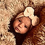 baby, infant, face, headband, bow, blanket, fur_texture, cozy, closeup, portrait, cute, soft, warm, child, newborn, expression, skin, eyes, fashion, indoor
