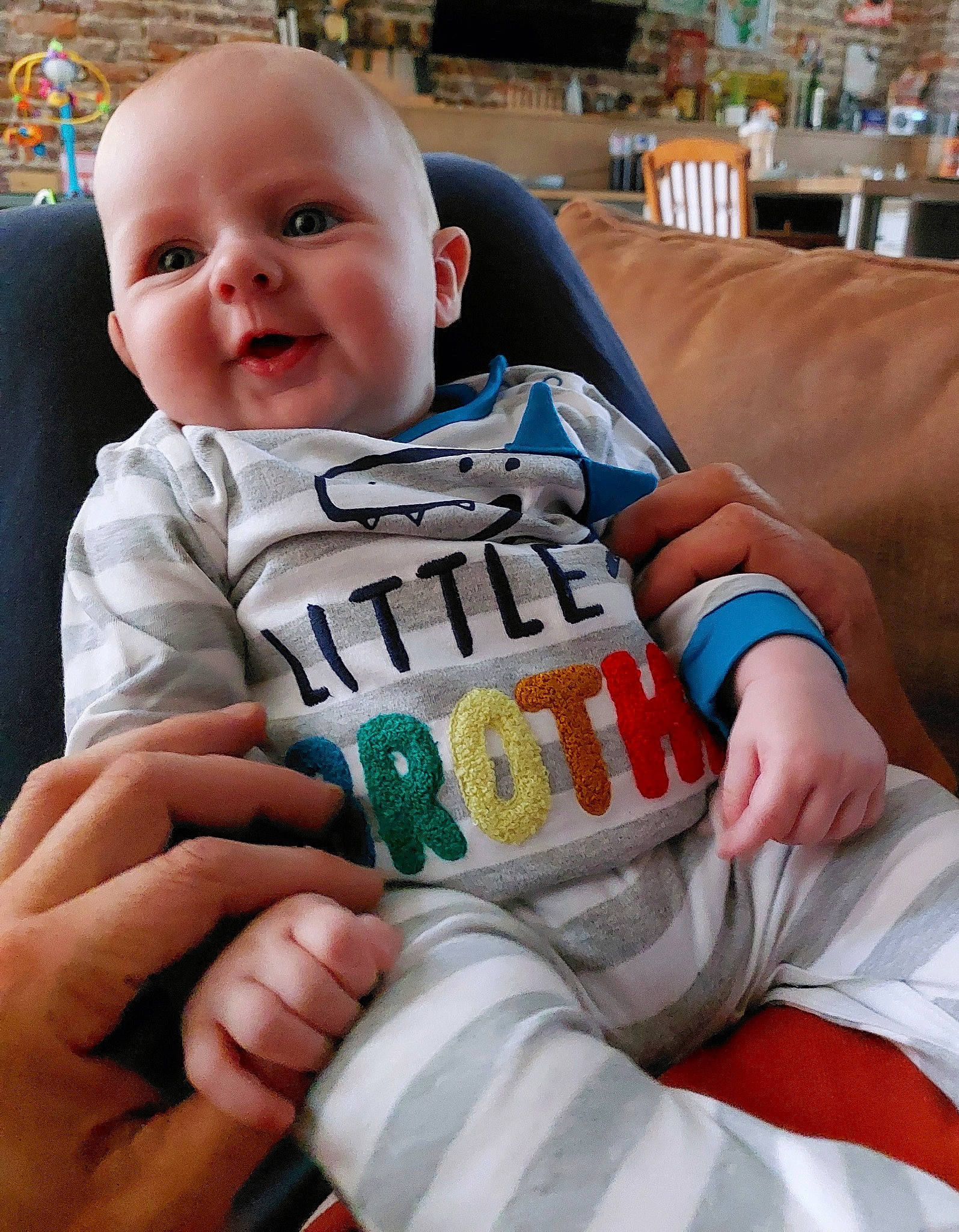 Simon a rejoint le concours — aidez-le/la à gagner de superbes lots ! baby, baby_products, baby_toddler_clothing, child, comfort, couch, finger, fun, hand, happy, human_body, linens, mouth, nail, person, room, sitting, sleeve, smile, t_shirt