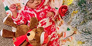 Jamaine is registered to the contest to win money with this photo: baby, blanket, carpet, christmas_lights, christmas_tree, cozy, decorations, festive, gift_wrap, hat, holiday_clothing, indoors, infant, peaceful, plush_toy, red_and_white, reindeer, sleeping, socks, wood_floor
