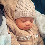 Jamaine is registered to the contest to win money with this photo: baby, sleeping, hat, pom_pom, knitted, blanket, cozy, warm, clothing, child, cute, infant, closeup, soft, bundle, face, portrait, relax, wearing, rest
