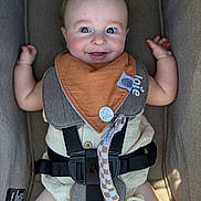 Walker joined the competition — help win amazing prizes! baby, infant, child, smiling, happy, portrait, car_seat, harness, bib, pacifier, toy, clothing, blue_eyes, brown_hair, sitting, indoors, vehicle, safety_belt, close_up, photography