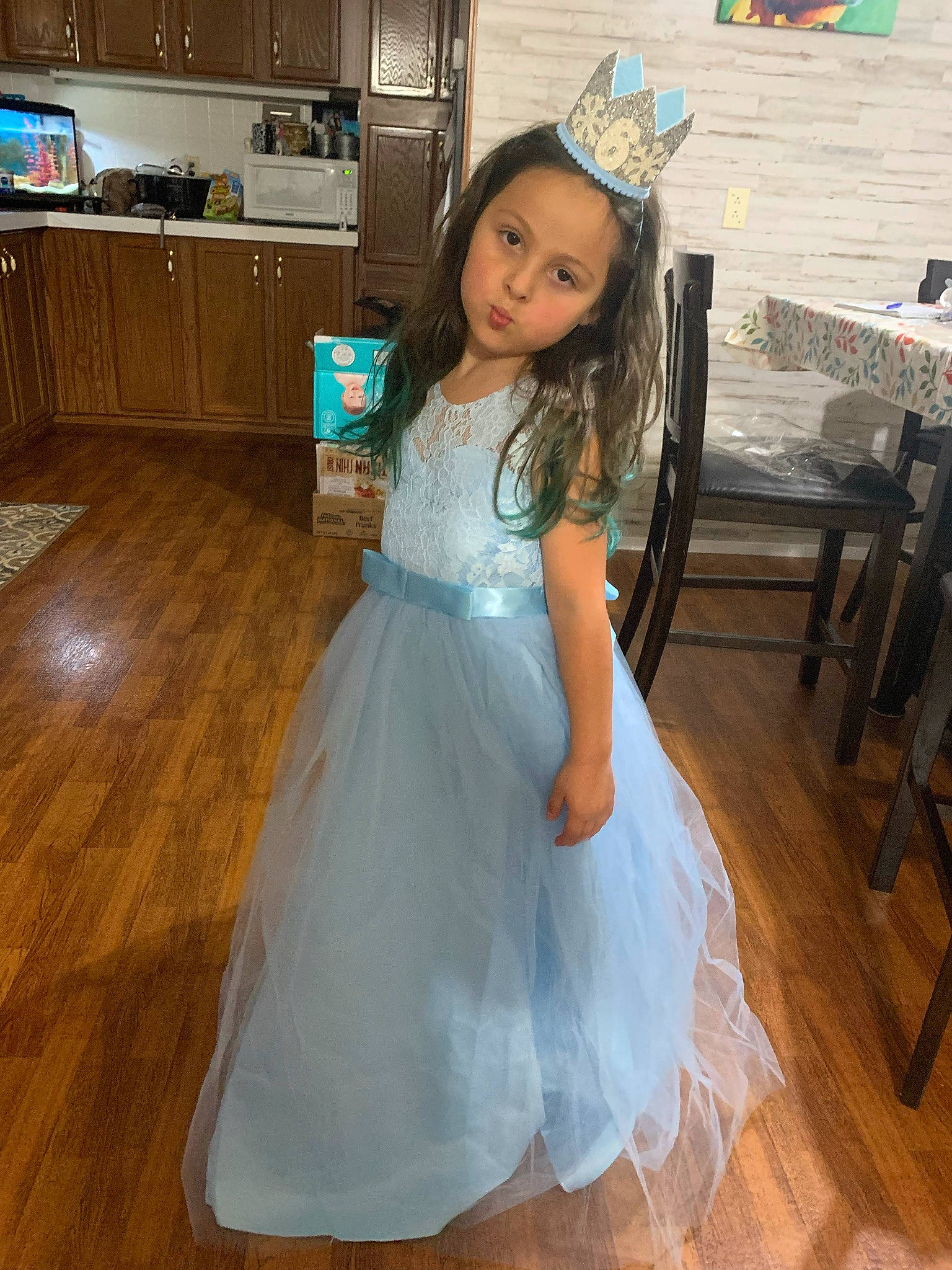 Brayleigh is registered to the contest to win money with this photo: bridal_clothing, bridal_party_dress, cabinetry, chair, countertop, dress, event, fashion_design, flooring, formal_wear, gown, happy, hardwood, kitchen_appliance, long_hair, person, television, toddler, trunk, waist