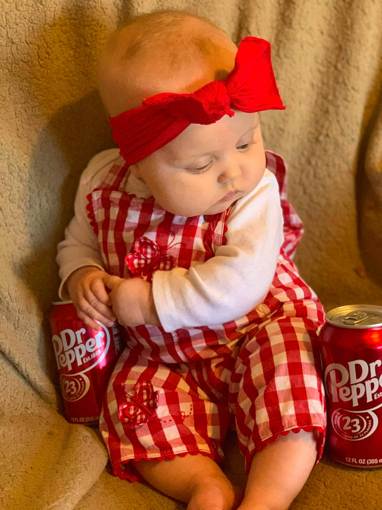 Tallie is registered to the contest to win money with this photo: baby, baby_toddler_clothing, brown_hair, cap, child, doll, dress, fashion_accessory, hat, headwear, human_body, human_leg, pattern, person, plaid, skin, sleeve, sock, tartan, toddler