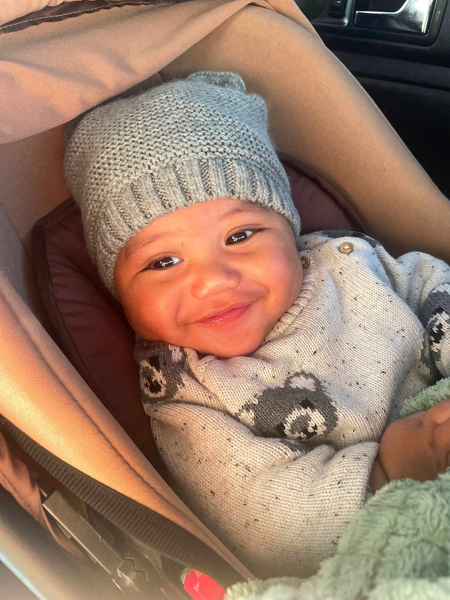 Elijah participe au concours pour gagner de l'argent avec cette photo : baby, smiling, knit_hat, sweater, bear_pattern, car_seat, child, cozy, warm, cute, infant, portrait, indoor, seatbelt, clothing, happy, face, person, blanket, soft_lighting