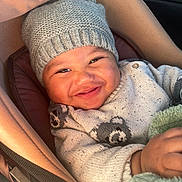 Elijah participe au concours pour gagner de l'argent avec cette photo : baby, smiling, hat, knitwear, sweater, bear_pattern, car_seat, blanket, cozy, child, infant, portrait, cute, warm, indoors, happy, person, face, clothing, baby_carrier