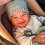 baby, smiling, hat, knitwear, sweater, bear_pattern, car_seat, blanket, cozy, child, infant, portrait, cute, warm, indoors, happy, person, face, clothing, baby_carrier