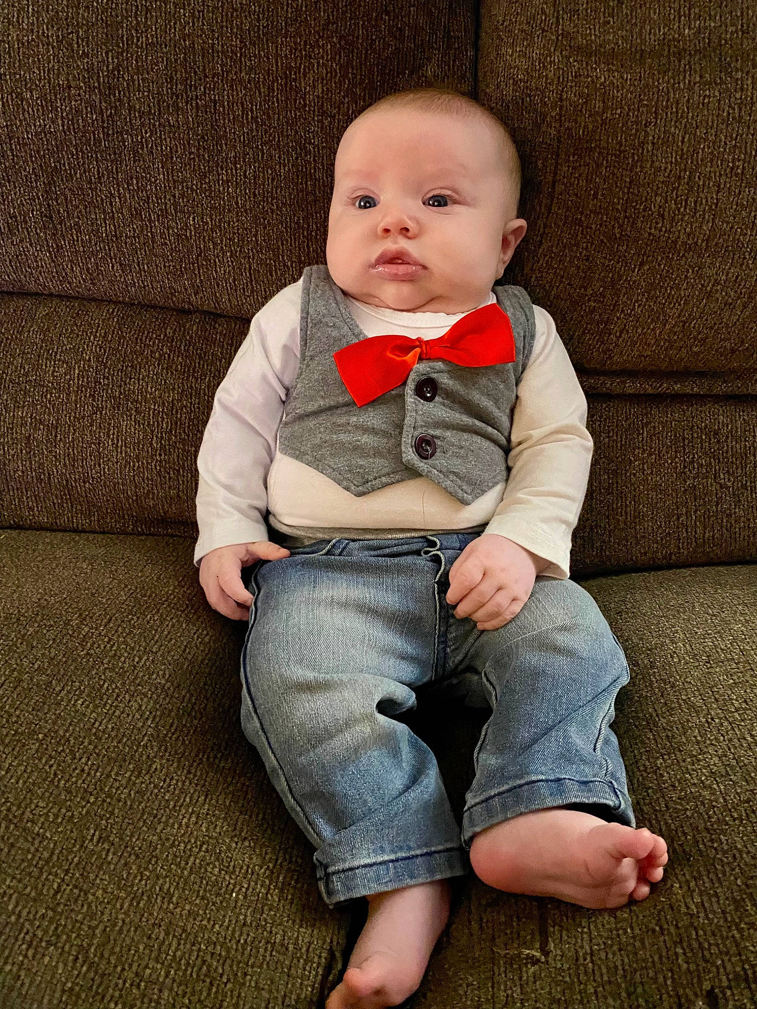 Eden is registered to the contest to win money with this photo: arm, baby, baby_toddler_clothing, barefoot, child, collar, comfort, denim, dress_shirt, eye, foot, grey, happy, knee, pattern, person, sitting, skin, sleeve, t_shirt