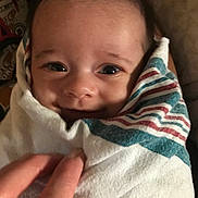 Katana is registered to the contest to win money with this photo: baby, smile, wrapped, blanket, striped, hand, face, eyes, infant, cute, cozy, closeup, person, newborn, soft, happy, warm, indoor, portrait, child