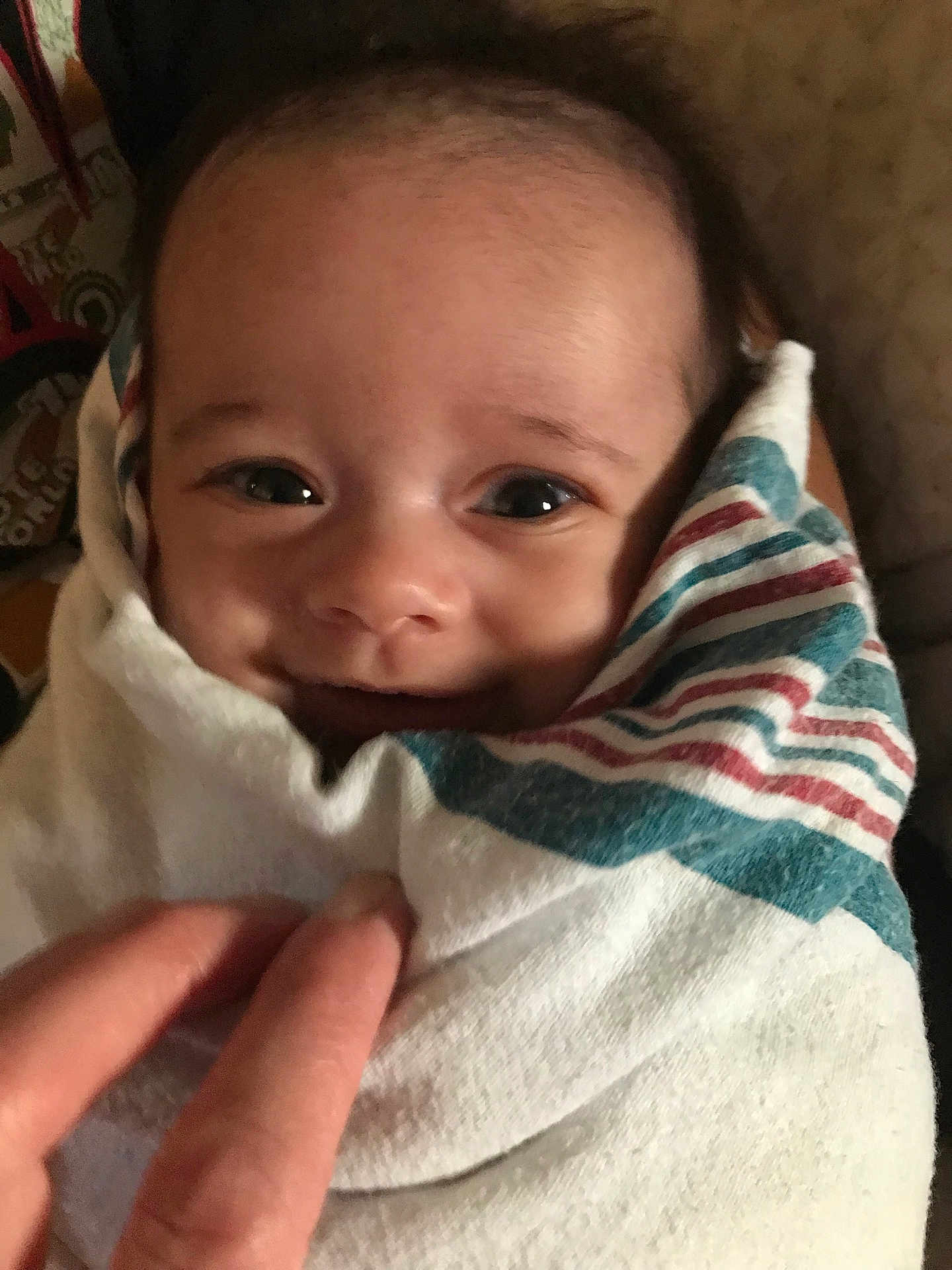 Katana is registered to the contest to win money with this photo: baby, smile, wrapped, blanket, striped, hand, face, eyes, infant, cute, cozy, closeup, person, newborn, soft, happy, warm, indoor, portrait, child