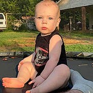 Billy Dean joined the competition — help win amazing prizes! baby, child, infant, trampoline, outdoor, sunlight, blue_eyes, black_onesie, skin, hair, grass, netting, blanket, foot, hand, face, person, nature, yard, house