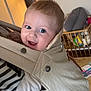 Louka participe au concours pour gagner de l'argent avec cette photo : baby, infant, smiling, face, eyes, baby_carrier, beige_carrier, striped_shirt, indoor, crib, nursery, toy, furniture, happy, person, portrait, wood_floor, button, couch, playpen