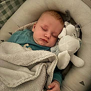 Louka participe au concours pour gagner de l'argent avec cette photo : baby, infant, sleeping, closed_eyes, blanket, plush_toy, stuffed_animal, bassinet, pillow, cozy, peaceful, hand, swaddle, bedding, textile, soft, head, cheeks, nursery, sleepwear