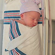 Colton is registered to the contest to win money with this photo: newborn, baby, infant, sleeping, swaddled, hospital, bassinet, crib, hat, striped_hat, blanket, swaddle, face, portrait, peaceful, nursery, medical, newborn_photography, indoors, resting
