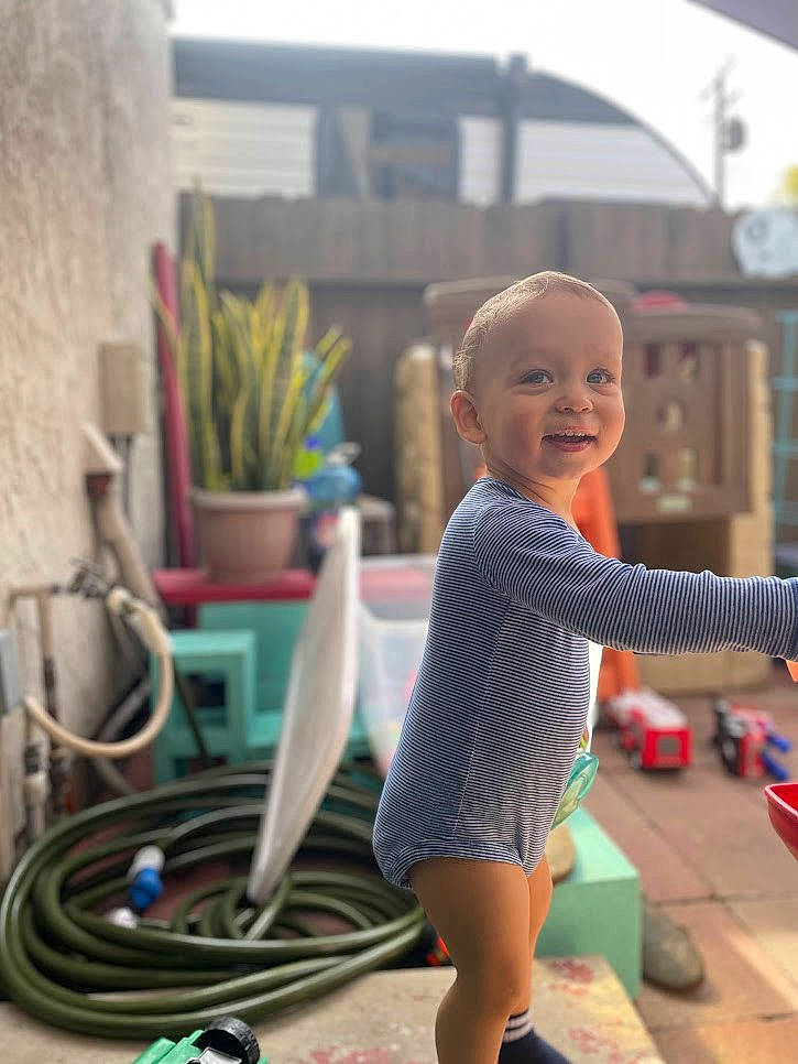 Wade is registered to the contest to win money with this photo: baby, cable, child, electric_blue, flooring, foot, fun, grass, happy, houseplant, human_leg, leisure, person, plant, play, recreation, sitting, smile, thigh, toddler