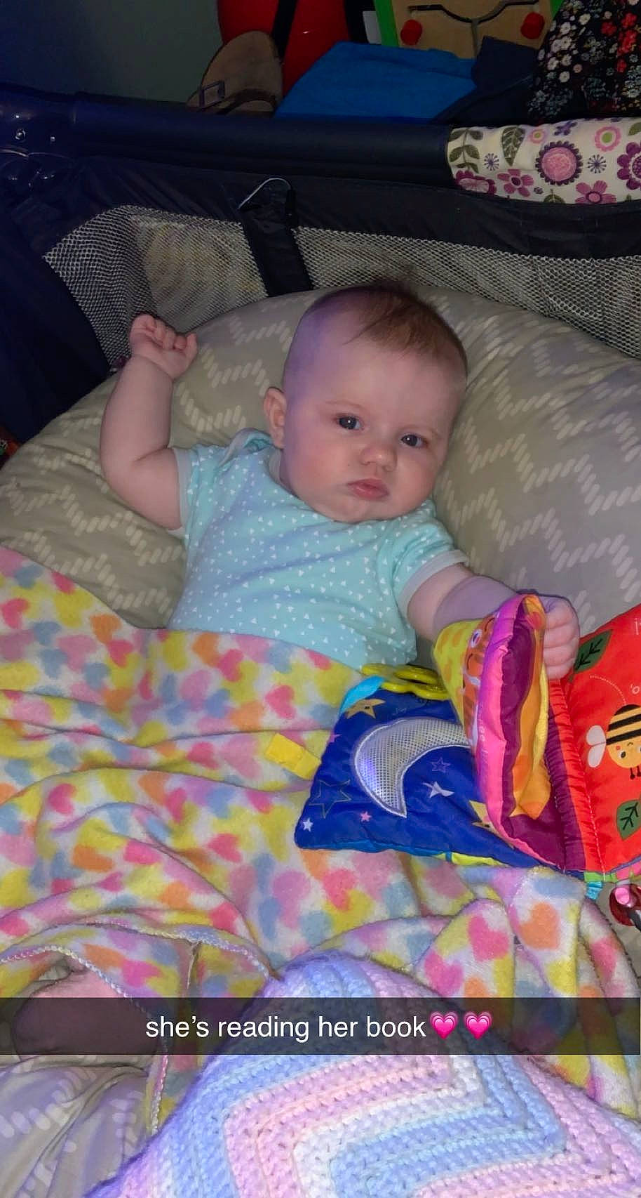 Renee is registered to the contest to win money with this photo: baby, baby_toddler_clothing, cheek, child, comfort, couch, eye, face, facial_expression, fun, head, iris, lap, linens, mammal, person, pink, skin, textile, toddler